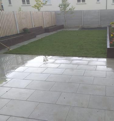 a backyard patio with a large lawn and a fenced in area