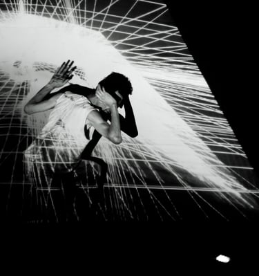 a woman in a white dress is dancing with a light