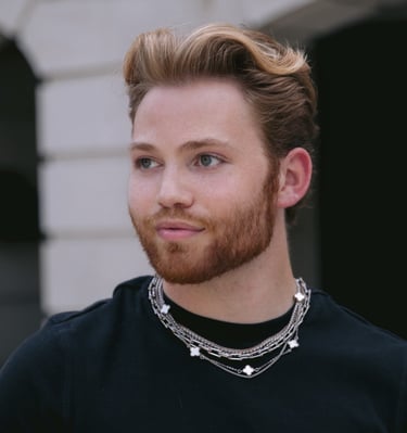 a man with a beard and a chain link necklace