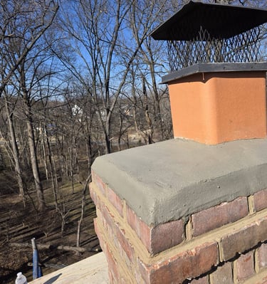 A newly installed concrete chimney crown and metal cap on a brick chimney by Roslyn Chimney