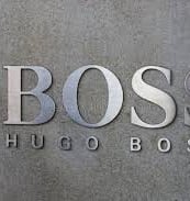a man in a suit and tie is standing in front of a wall with the