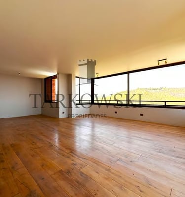 piso de departamento con suelo de madera murallas color blanco, ventanas amplias y bien iluminado