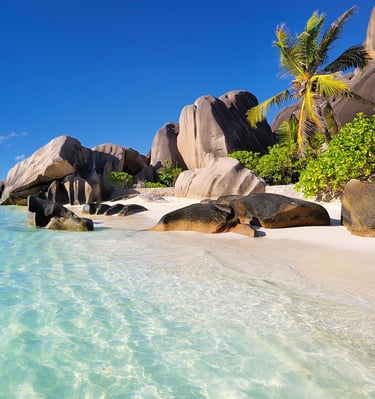 Idyllic Seychelles beach with granite boulders, white sand, and turquoise water.