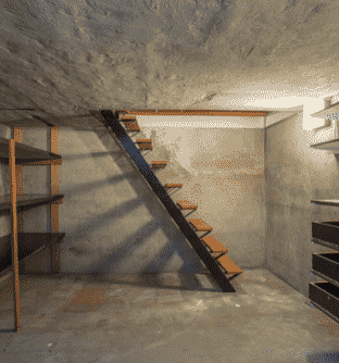a staircase leading to a basement with a staircase leading up to a second floor