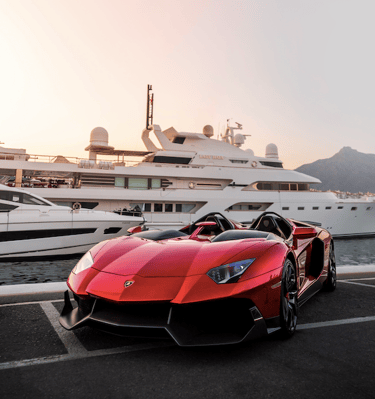 a red sports car parked in front of a yacht