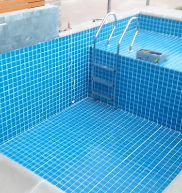 a pool with a blue tiled pool and a wooden deck
