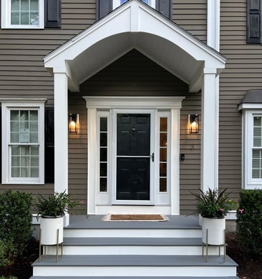 a house with a black door and white steps leading up to a front door