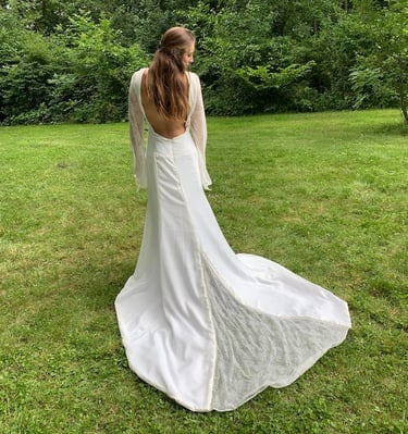 a woman in a white dress standing in the grass