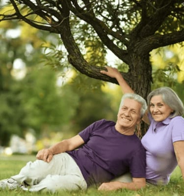 a man and woman sitting on the grass