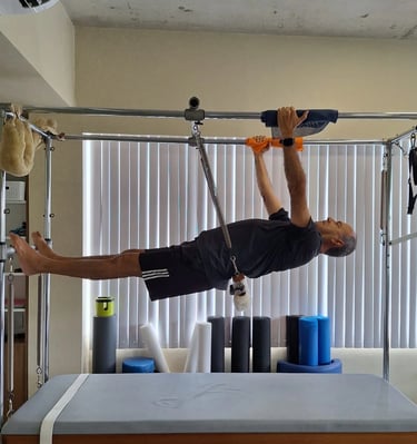 Aluno idoso no aparelho de pilates