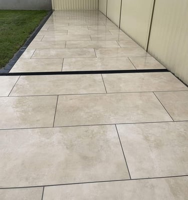 a patio with a white tile floor and a fenced in area