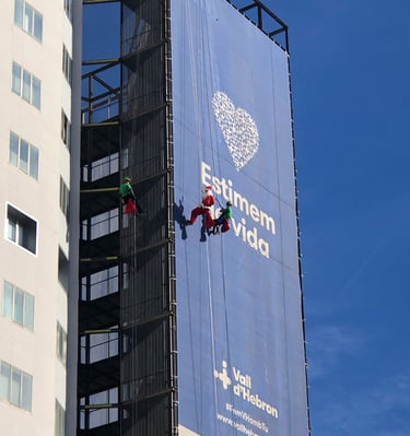 a man on a rope rope with a banner on the side of a building