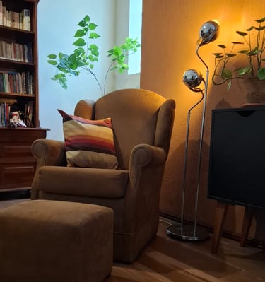 Espaço de atendimento online com poltrona confortável, almofada colorida e iluminação aconchegante, 