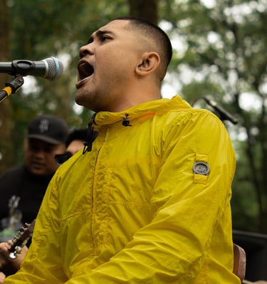 a man in a yellow jacket singing into a microphone