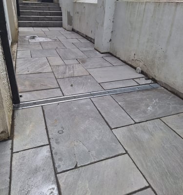 a tiled floor with a drain in the middle of the floor