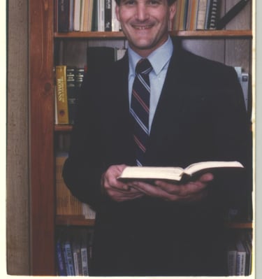 a man in a suit and tie is holding a book