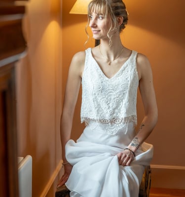 a woman in a white dress sitting on a chair