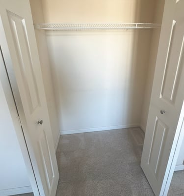 an empty closet with a closet door open and a closet with a shelf