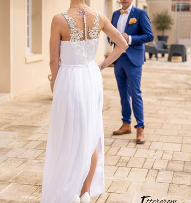 a bride and groom standing in front of a house
