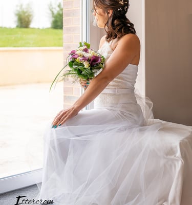 a bridesmaid sitting on a bench in a window