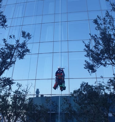a man in a suit is cleaning a glass building