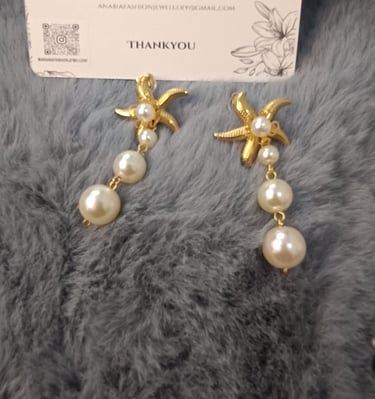 a pair of earrings with pearls and pearls