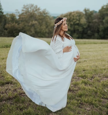 a pregnant woman in a white dress with a flower crown