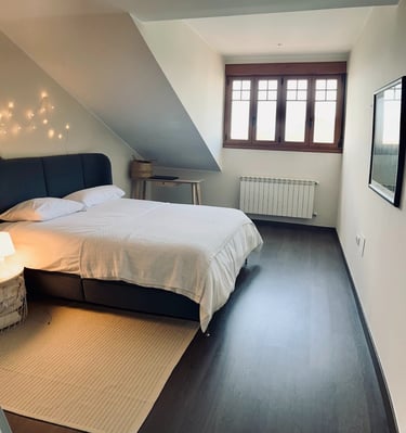 The main bedroom, with large bed and view of the marina and fishing boats.