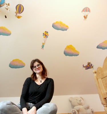 artiste Marie Hardy devant peinture murale en couleurs chambre enfant Aunay sur Odon Caen Normandie