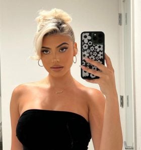 a woman in a black dress is taking a selfie