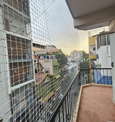 Technician from Sukumari Safetu Nets carefully fitting a net around a rooftop area.
