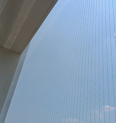 View from inside a balcony protected by a pigeon net, showing clear visibility and safety.