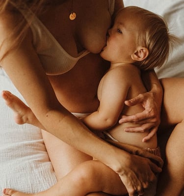 bébé qui tete au sein de maman dans le lit