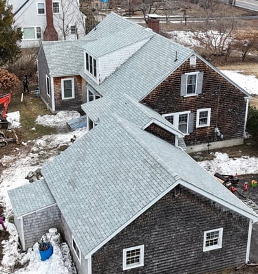 Aerial view of residential home renovation featuring an orange Kubota excavator and construction crew.