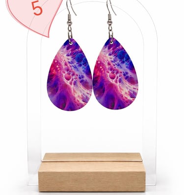 Purple and pink teardrop earrings with an abstract fluid art design on a clear display stand.