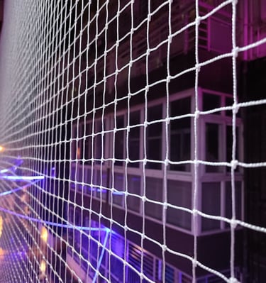 Close-up of a sturdy pigeon net securely fitted on a balcony railing in Bellandur.