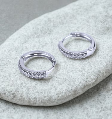 Par de aretes plateados con zirconias sobre una piedra