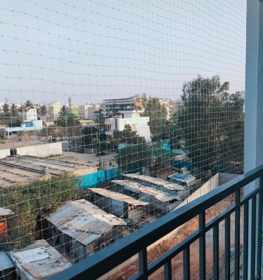 Close-up of a sturdy anti-pigeon net installed on a balcony railing.