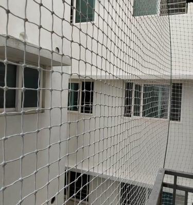 Technician from Arjilli Enterprises installing a balcony safety net with care and precision.