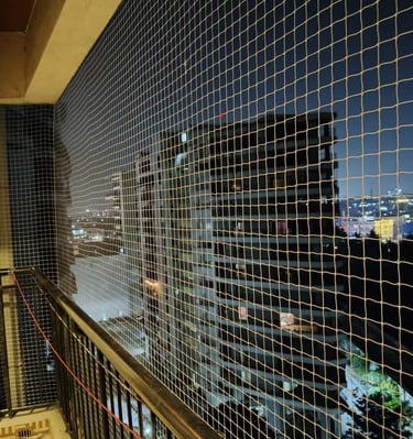 Wide shot of a residential balcony in Velacherry fitted with a durable safety net.