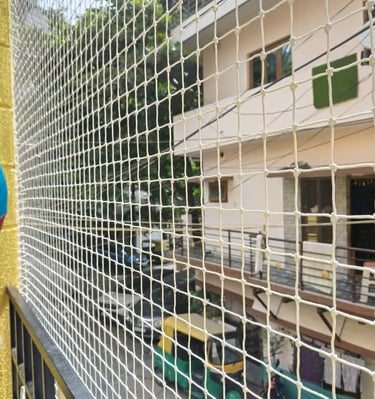 Child playing safely behind a balcony net installed by Arjilli Enterprises.