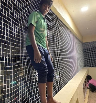 Child playing safely behind a balcony safety net installed by Arjilli Enterprises.