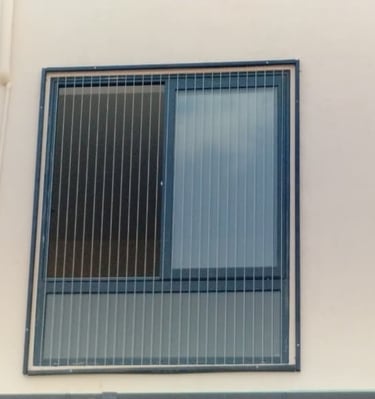 Close-up of a sleek invisible grill installed on a Besant Nagar balcony with a sea view