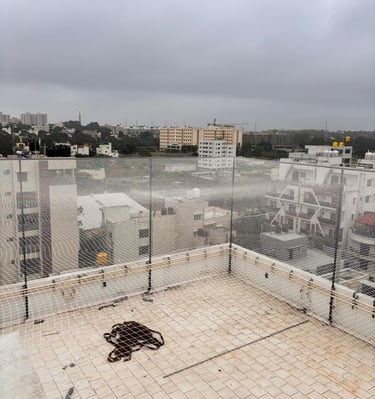 A freshly installed terrace sports net protecting a rooftop cricket pitch in Chennai under bright su