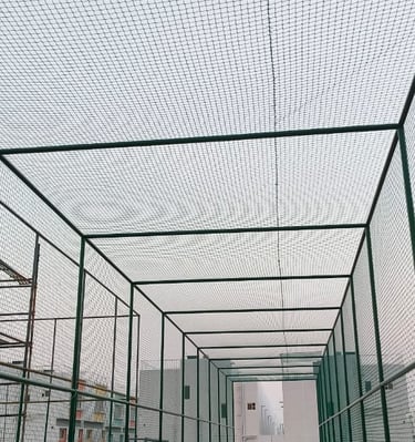 Football nets stretched across a spacious rooftop sports area at sunset.
