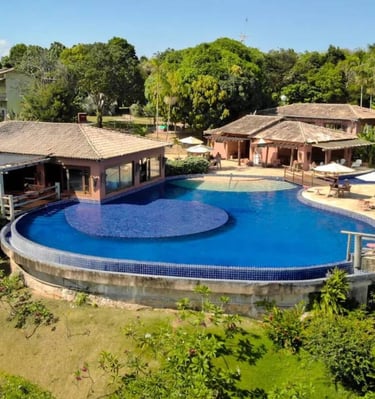 Piscina per adulti e bambini con bordo infinito e vista panoramica sulla foresta e il mare