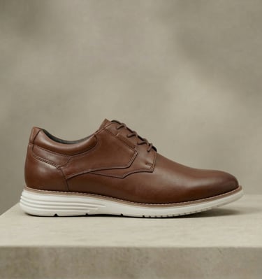 Zapato de vestir de cuero marrón claro, con cordones y una suela blanca y ligera