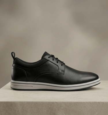 Zapato de vestir de cuero negro, con cordones y una suela blanca y ligera