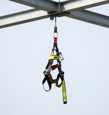 3M DBI-SALA fall protection harness hanging on a metal beam