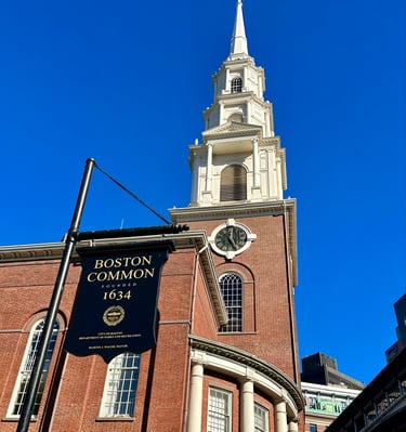 A sign advertising Boston Commons in front of Park Street Church